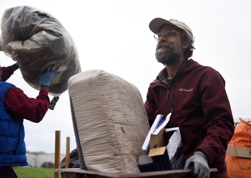 Host of the cleanup John Trapp carries a box of trash